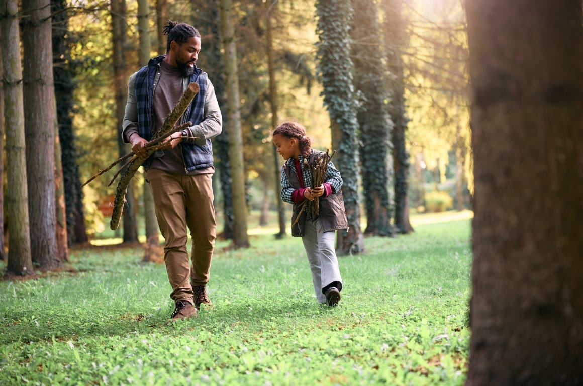 A man and his daughter collecting sticks for bonfire night